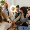 A group of diverse coworkers engage in a team huddle in a contemporary office environment